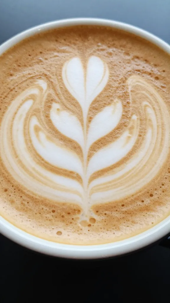 closeup of a cappuccino with artful foam in a small ceramic cup